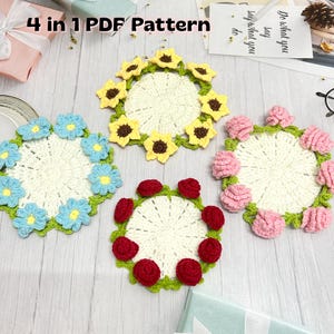May include: Four handmade crochet coasters in a variety of floral designs. The coasters feature a central cream-colored circle surrounded by blue flowers, yellow sunflowers, pink roses, and red roses. The text "4 in 1 PDF Pattern" is visible.