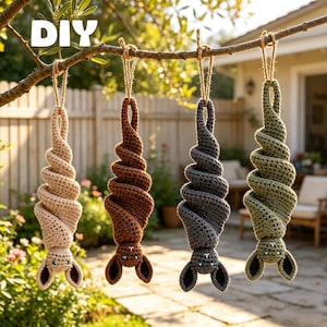Può includere: Quattro pipistrelli decorativi all'uncinetto nei colori beige, marrone, grigio scuro e verde oliva, con corpo a spirale, orecchie a punta e piccoli occhi, appesi a un ramo con spago. Il testo DIY è visibile in alto a sinistra.