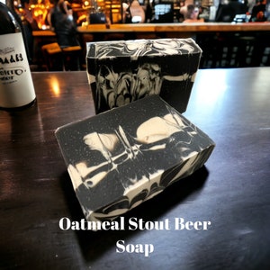 May include: Two bars of black and white marbled soap. The soap is labeled "Oatmeal Stout Beer Soap".