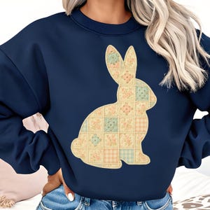 Puede incluir: Sudadera azul marino con un diseño de conejo de retazos. El conejo está compuesto por cuadrados con patrones florales y a cuadros en colores pastel. Una parte superior cómoda e informal para primavera o Pascua.