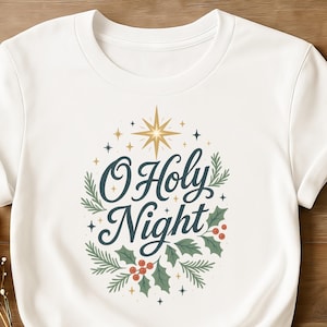May include: White t-shirt with a festive design. The design features the text "O Holy Night" in a script font, surrounded by a star, sprigs, and holly berries. The shirt is a crew neck style.