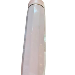 Peut inclure: Une gourde isotherme rose p&acirc;le, mince, avec un bord et un bouchon argent&eacute;s m&eacute;talliques. La bouteille a une finition lisse et brillante et une base arrondie. Le bouchon est de couleur rose p&acirc;le assortie.