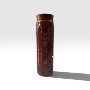 May include: A tall, maroon-colored travel mug with a gold band near the top. The mug has a ridged design and a dark brown lid. The mug is standing upright on a white surface.