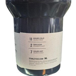 May include: A dark gray insulated tumbler with a white label. The label indicates the tumbler keeps contents cold for 11 hours, iced for 2 days, and hot for 7 hours. The brand name and website are also visible.