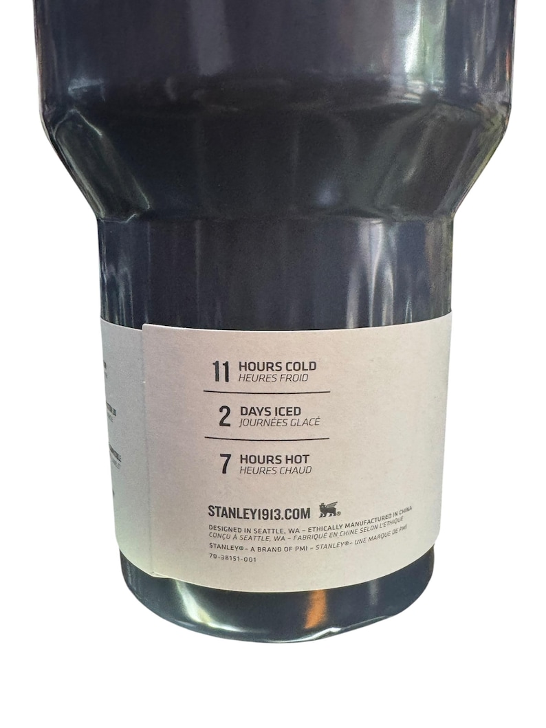May include: A dark gray insulated tumbler with a white label. The label indicates the tumbler keeps contents cold for 11 hours, iced for 2 days, and hot for 7 hours. The brand name and website are also visible.