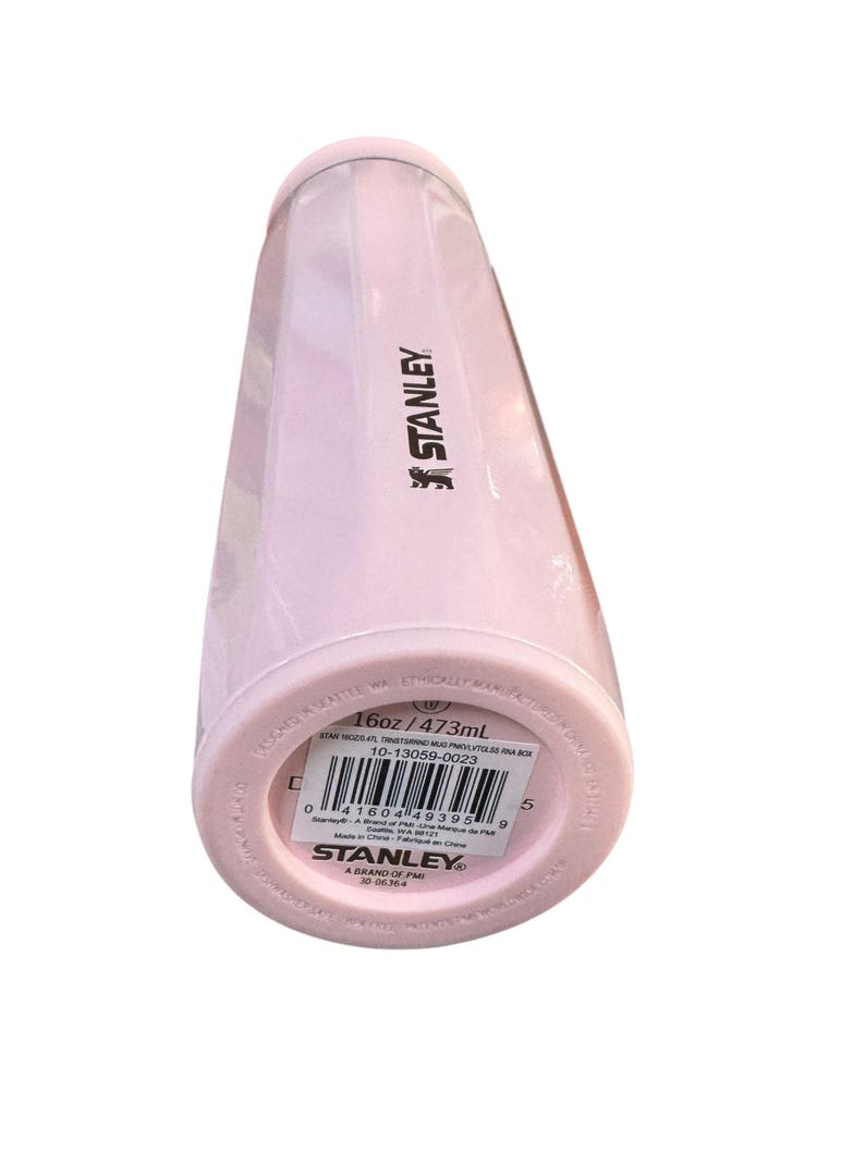 Peut inclure: Une gourde Stanley rose clair. La bouteille est cylindrique avec un couvercle &agrave; visser. Le fond de la bouteille porte une &eacute;tiquette avec le texte "16oz / 473ml". Le logo Stanley est imprim&eacute; sur le c&ocirc;t&eacute; de la bouteille.