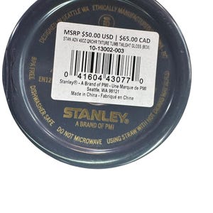May include: A dark blue Stanley tumbler with a textured finish. The product label includes the text "STAN ADV 40OZ QNCHR TXTURE TUMB TWLGHT GLOSS (BOX)" and "BPA FREE". The tumbler is designed in Seattle, WA, and is dishwasher safe.