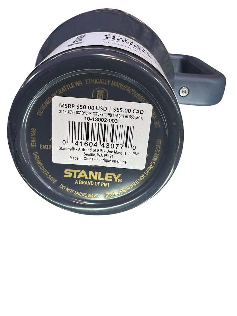 May include: A dark gray Stanley 40oz tumbler with a handle. The bottom of the tumbler has a product label with the brand name and product information. The tumbler is designed in Seattle, WA.