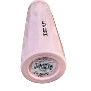 Peut inclure: Gobelet isotherme Stanley rose clair. Le gobelet cylindrique est dot&eacute; d'un couvercle vissable. Le bas du gobelet indique "16oz / 473ml". Le logo Stanley est visible sur le c&ocirc;t&eacute;.