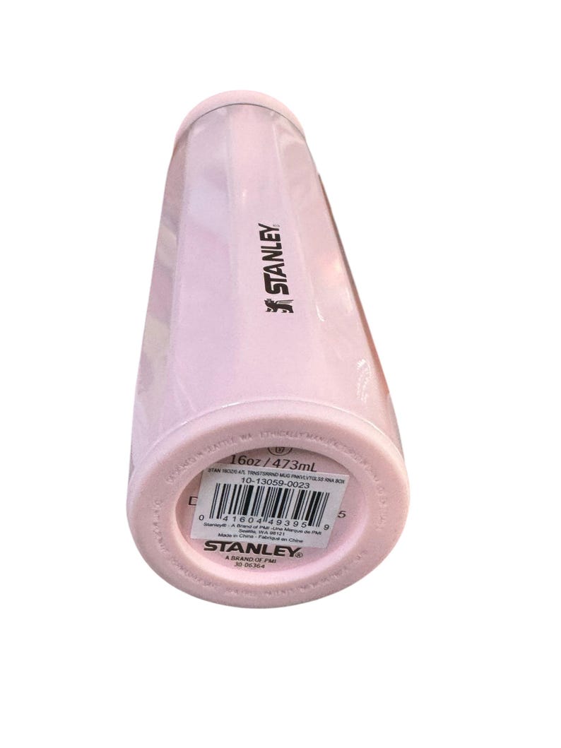 Peut inclure: Gobelet isotherme Stanley rose clair. Le gobelet cylindrique est dot&eacute; d'un couvercle vissable. Le bas du gobelet indique "16oz / 473ml". Le logo Stanley est visible sur le c&ocirc;t&eacute;.