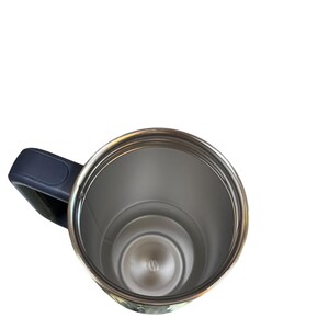 May include: A stainless steel travel mug with a dark blue handle. The interior of the mug is silver, and the rim is a shiny silver color. The mug is empty and appears to be clean.