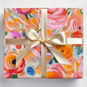 May include: A gift box wrapped in colorful floral patterned paper with a gold satin ribbon tied in a bow.