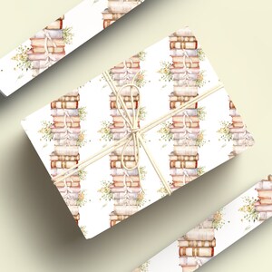 May include: White gift wrap with a repeating pattern of stacks of vintage books tied with twine and small sprigs of flowers.