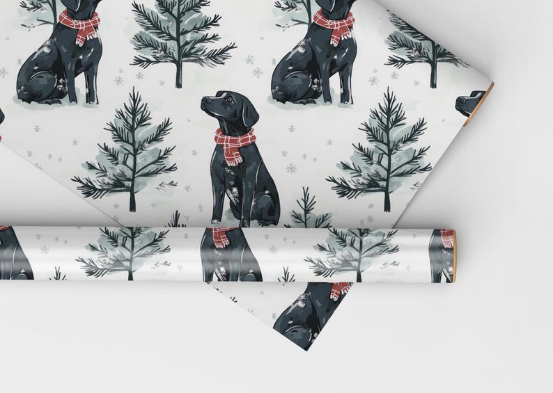 K&ouml;nnte beinhalten: Geschenkpapier mit einem sich wiederholenden Muster aus schwarzen Labrador Retrievern, die rot-wei&szlig; karierte Schals tragen, vor dem Hintergrund stilisierter immergr&uuml;ner B&auml;ume und Schneeflocken auf wei&szlig;em Grund. Eine Rolle des gleichen Papiers ist ebenfalls sichtbar.