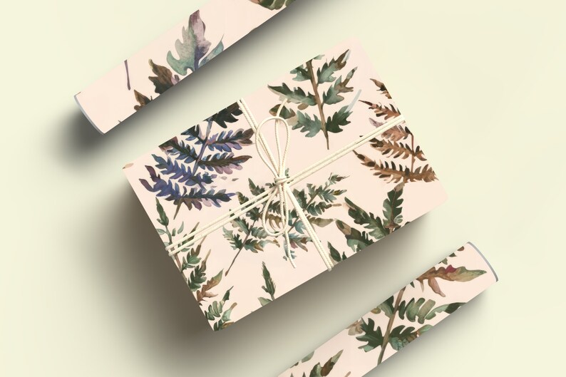 May include: A gift box wrapped in pink wrapping paper with a watercolor fern pattern. The box is tied with twine and has a bow.