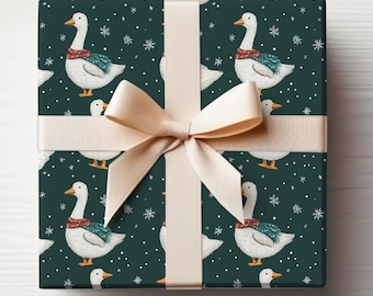 May include: Gift-wrapped present with a dark teal background featuring a pattern of white geese wearing scarves and snowflakes. A beige ribbon and bow are tied around the gift. The bow is centered on the top of the gift.