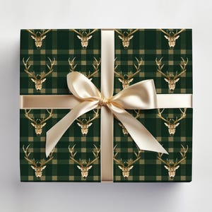 May include: Green and beige plaid wrapping paper with a gold stag head pattern. A gold ribbon is tied around the paper.