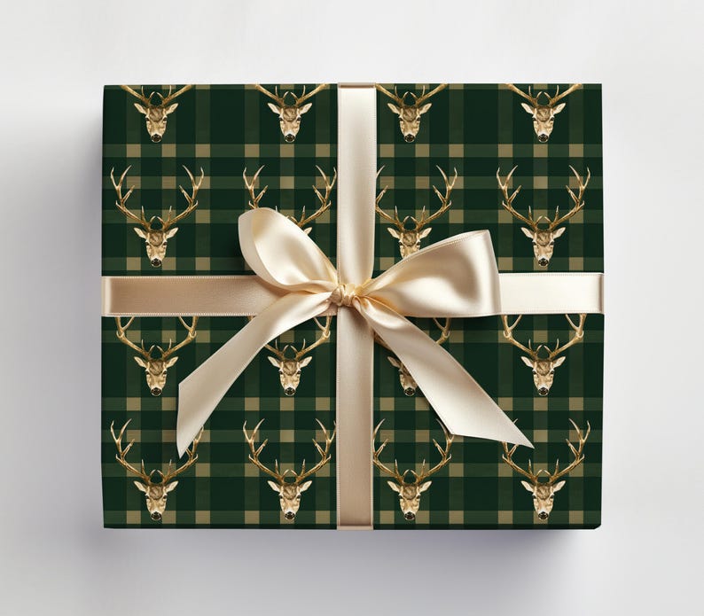 May include: Green and beige plaid wrapping paper with a gold stag head pattern. A gold ribbon is tied around the paper.