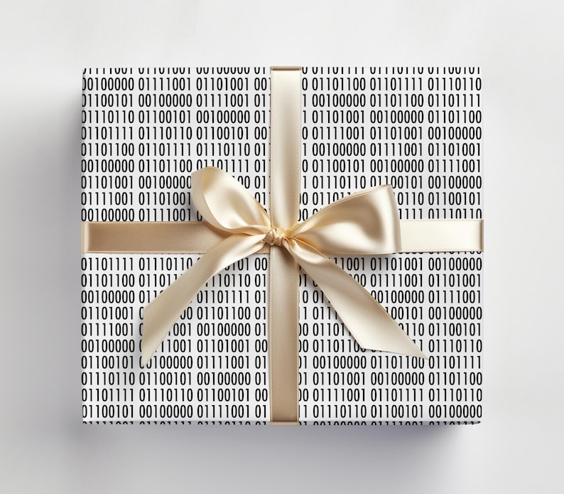May include: A wrapped present with a white background and a gold satin ribbon. The wrapping paper is white with a repeating pattern of black binary code. The bow is tied in a classic style.