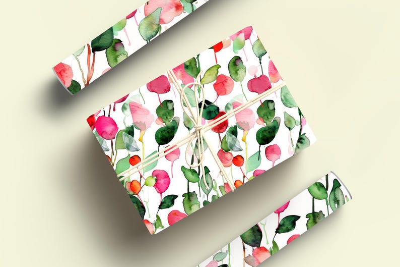 May include: A white gift wrap with a watercolor floral pattern featuring pink and red flowers and green leaves. The gift wrap is rolled up and tied with twine.