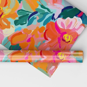 May include: A roll of colourful floral wrapping paper with a bright orange, pink and teal abstract floral pattern. The paper is rolled up and partially unrolled, revealing the pattern.