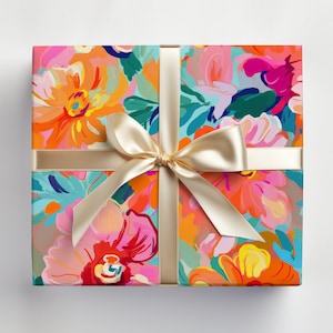 May include: A gift box wrapped in colourful floral patterned paper with a gold satin ribbon tied in a bow.