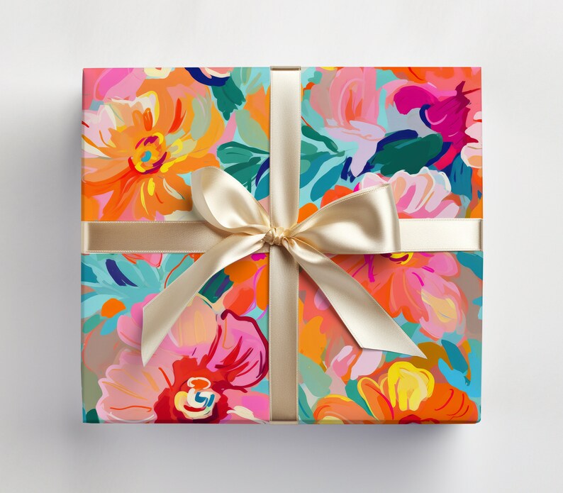 May include: A gift box wrapped in colourful floral patterned paper with a gold satin ribbon tied in a bow.