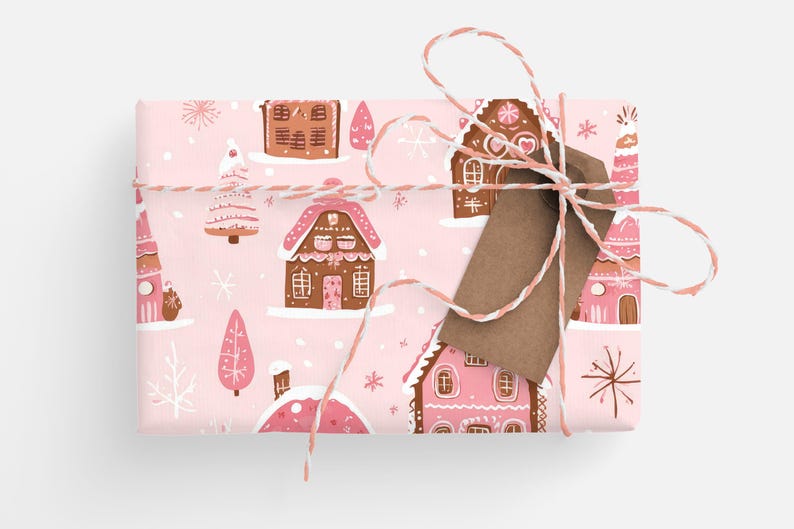 May include: Pink wrapping paper with a repeating pattern of gingerbread houses, trees, and snowflakes. The paper is tied with twine and a brown gift tag.