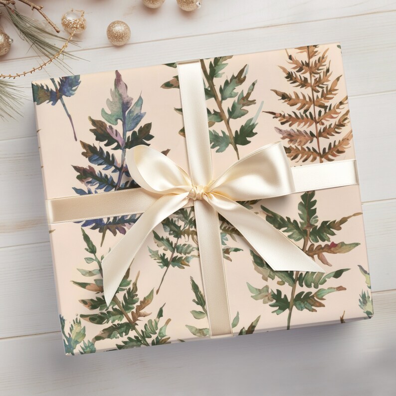 May include: A gift box wrapped in cream-colored paper with a watercolor fern pattern. The box is tied with a cream-colored satin ribbon with a bow.
