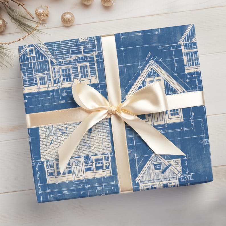 May include: Blue and white wrapping paper with a blueprint design of houses. The paper is tied with a cream-colored ribbon and bow.