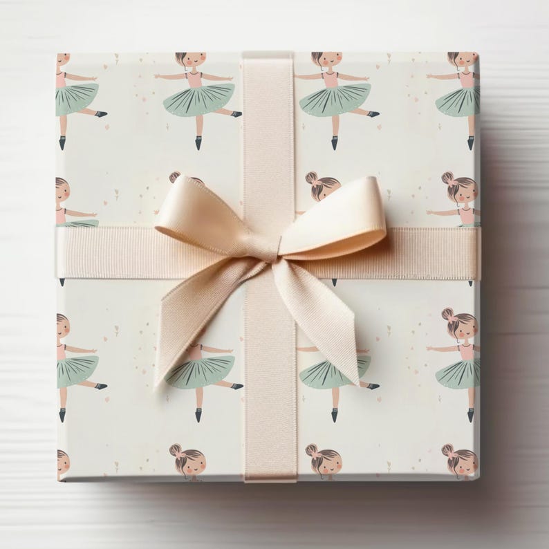 May include: A white gift box with a beige ribbon tied in a bow. The box is wrapped in wrapping paper with a pattern of little girls wearing green tutus and pink ballet shoes.