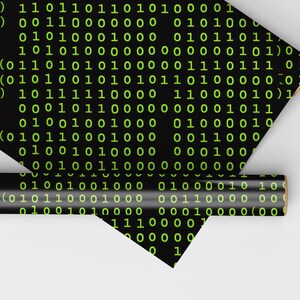 Peut inclure: Papier cadeau noir avec un motif r&eacute;p&eacute;t&eacute; de code binaire vert. Une section enroul&eacute;e du papier est &eacute;galement visible, montrant le m&ecirc;me motif. Le papier est pos&eacute; sur une surface blanche.