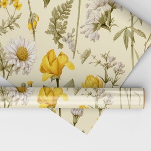 Pu&ograve; includere: Un rotolo di carta da regalo con un motivo floreale con fiori gialli e bianchi, foglie verdi e una farfalla.