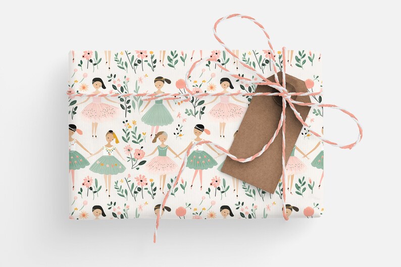 May include: A white gift wrap with a repeating pattern of ballerinas in pink and green tutus, surrounded by pink and green flowers. The gift is tied with a white and pink twine and a brown gift tag.