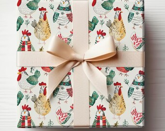 May include: A square gift box wrapped in patterned paper featuring watercolor illustrations of chickens in various colors. The chickens are adorned with scarves and surrounded by small green trees. A beige ribbon and bow are tied around the box.
