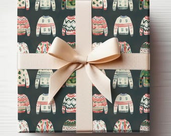 May include: A gift wrapped in dark blue wrapping paper with a pattern of colorful Christmas sweaters. The paper is tied with a cream-colored ribbon.