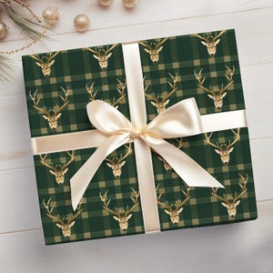 May include: Green and gold plaid gift wrap with a repeating pattern of gold stag heads. The wrap is tied with a cream satin ribbon.