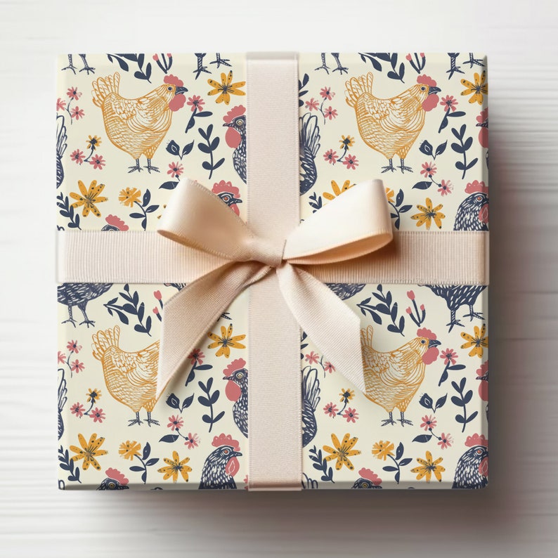 Puede incluir: Una caja de regalo envuelta en papel crema con un patr&oacute;n repetitivo de pollos amarillos, flores rosas y hojas azules. La caja est&aacute; atada con una cinta de sat&eacute;n crema.