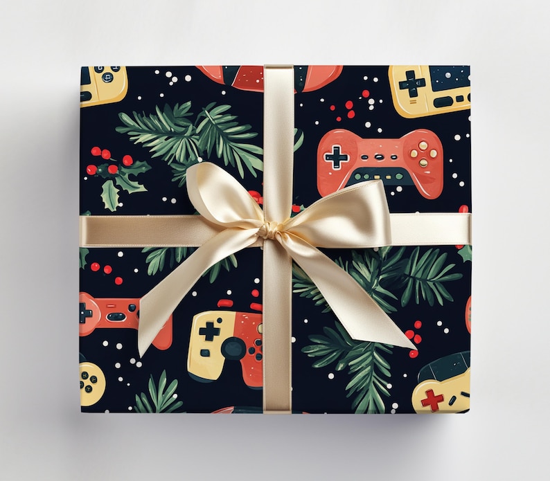 K&ouml;nnte beinhalten: Ein verpacktes Geschenk mit dunkelblauem Hintergrund, das ein Muster aus roten und gelben Videospiel-Controllern sowie gr&uuml;ne Zweige und rote Beeren zeigt. Das Geschenk ist mit einem goldenen Band und einer Schleife gebunden.