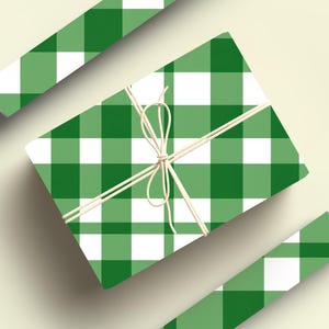 May include: A green and white gingham gift wrap with a white ribbon tied around it. Two rolls of the same wrapping paper are also shown.