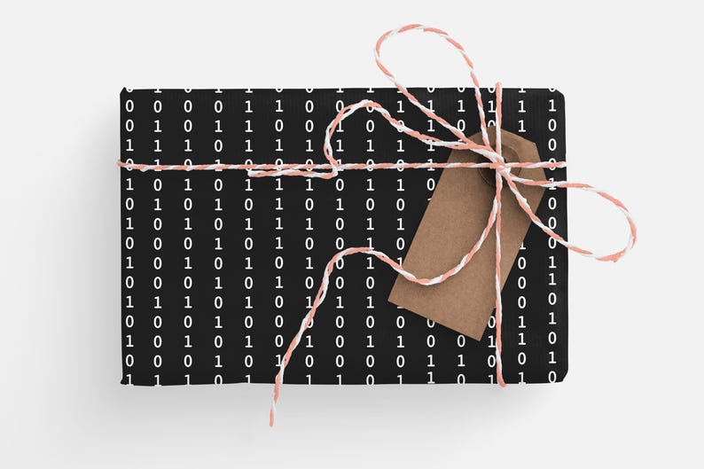 May include: A black gift box with a white binary code pattern wrapped with pink and white twine and a brown gift tag.