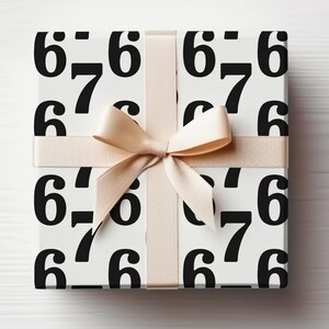 Pode incluir: Uma caixa de presente embrulhada em papel branco com números pretos 6 e 7. É amarrada com uma fita e laço bege, criando uma apresentação elegante e moderna.
