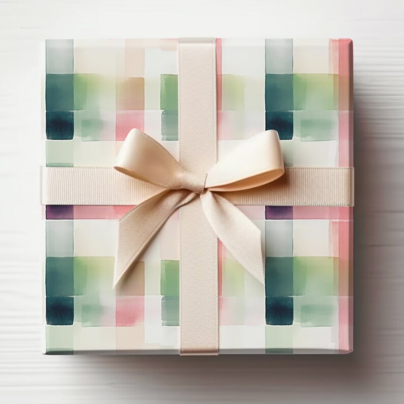 May include: A gift box wrapped in white paper with a geometric pattern of pink, green, and blue watercolor squares. The box is tied with a cream-colored satin ribbon.