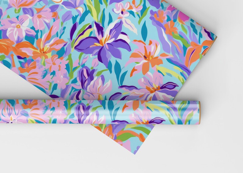May include: A roll of blue wrapping paper with a floral pattern featuring pink, orange, purple, and green flowers. The paper is rolled up and partially unrolled, showing the pattern.