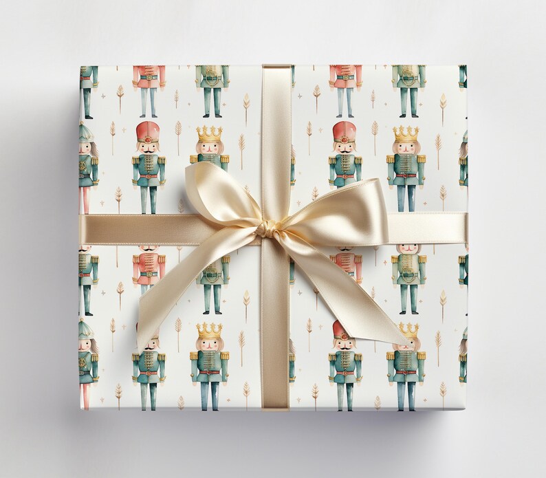 May include: White wrapping paper with a repeating pattern of watercolor nutcracker soldiers. The nutcrackers are wearing red, green, and blue uniforms with gold accents. A gold ribbon is tied around the paper.