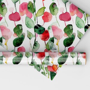 May include: A roll of white wrapping paper with a repeating pattern of pink and red watercolor flowers and green leaves.