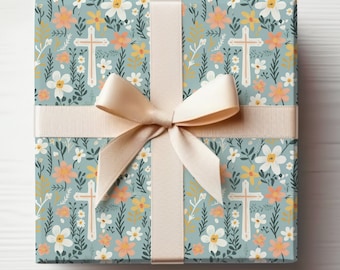 May include: A gift box wrapped in blue and white floral patterned paper with a beige ribbon and bow. The paper features a repeating pattern of white flowers, green leaves, and small crosses.