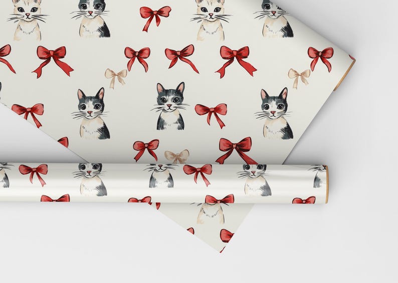 May include: Wrapping paper with a repeating pattern of watercolour cat portraits and red bows on a cream background. A roll of the paper is visible, partially unrolled, showing the design. The cats are in various poses.