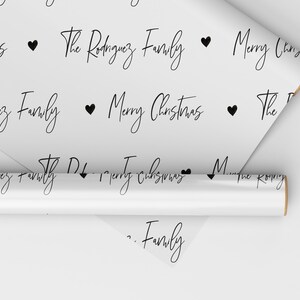 May include: White wrapping paper with a repeating pattern of black hearts, the text "Merry Christmas" and "The Rodriguez Family".