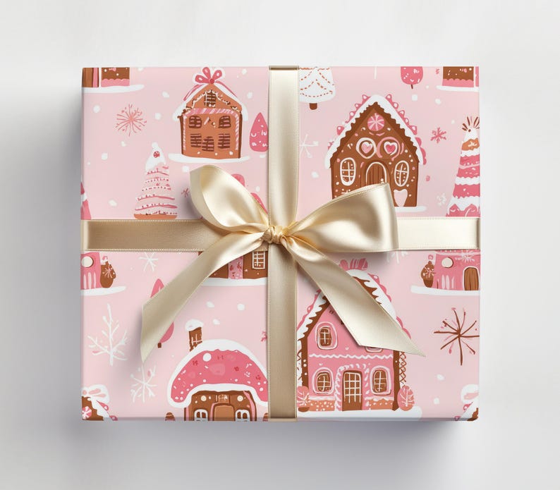 May include: Pink wrapping paper with a repeating pattern of gingerbread houses and Christmas trees. The paper is tied with a gold ribbon.